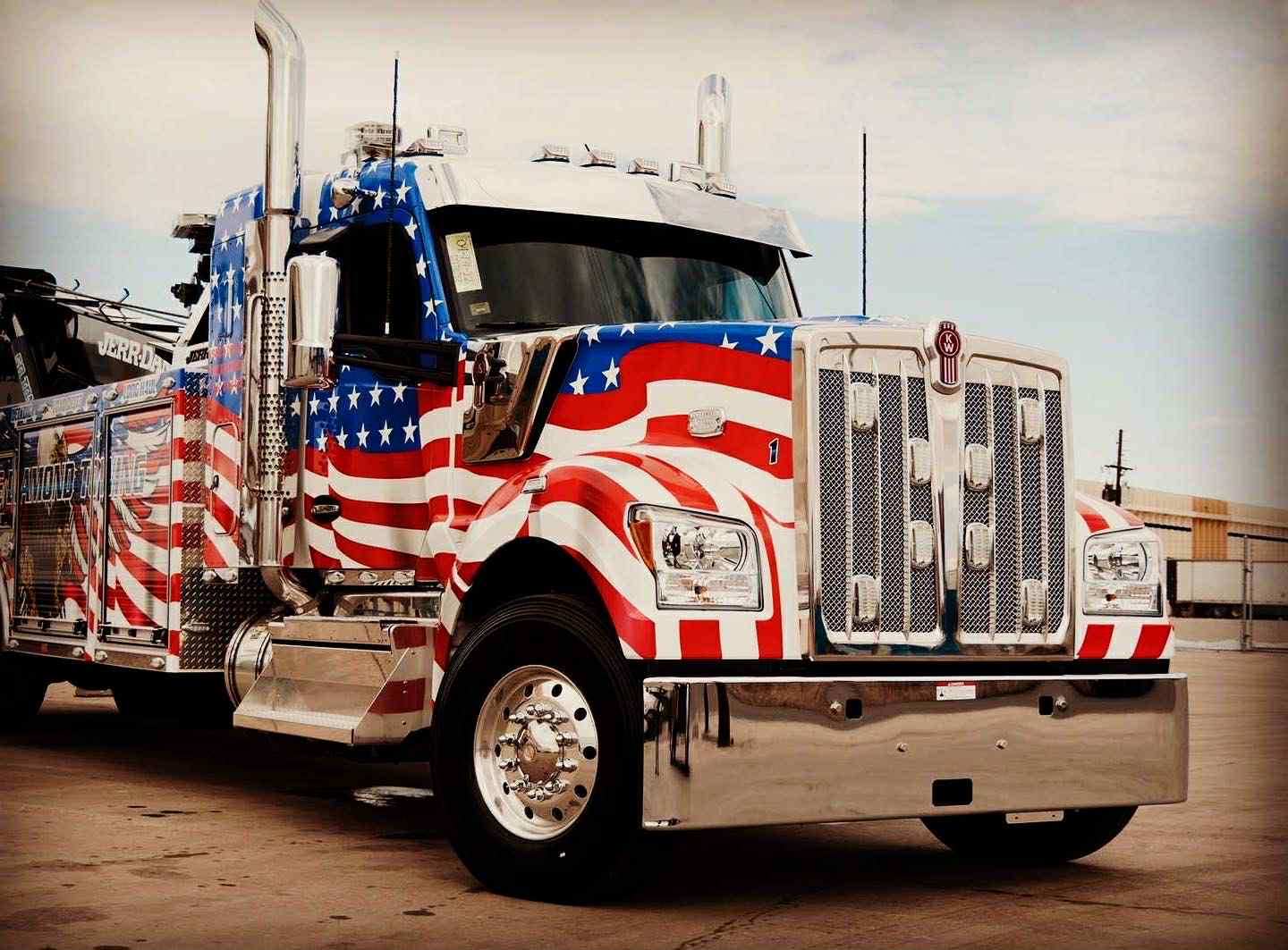 Semi-truck tow truck painted with the American flag.