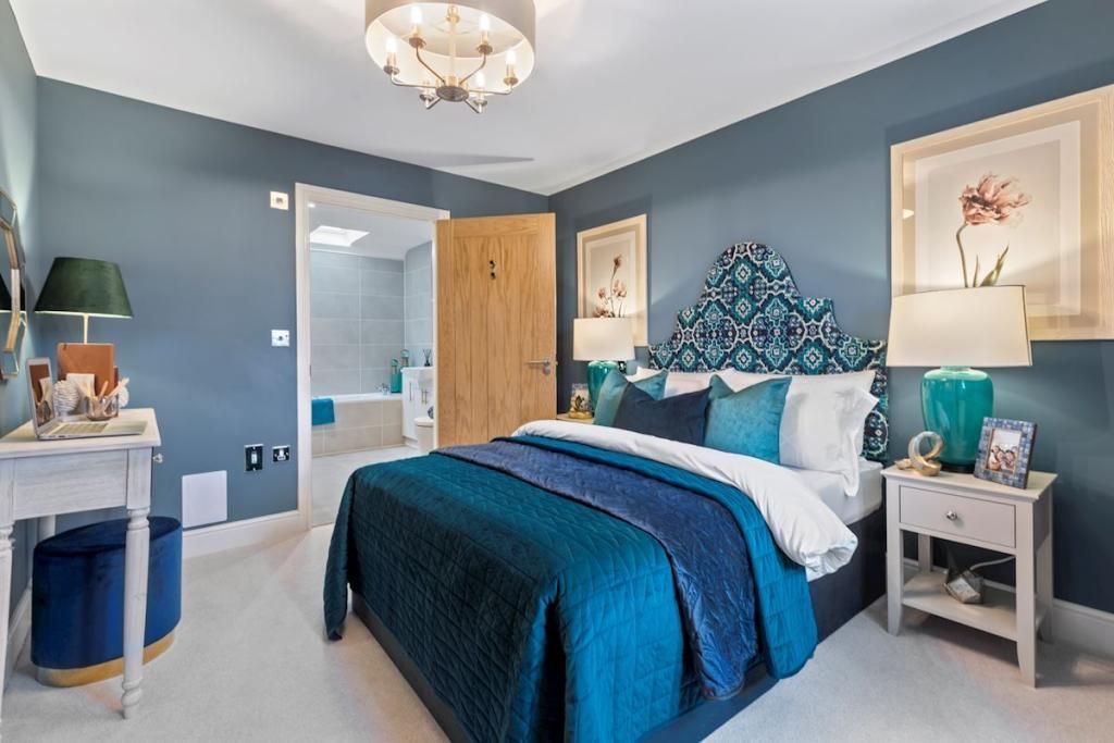 A bedroom with blue walls and a blue bed.