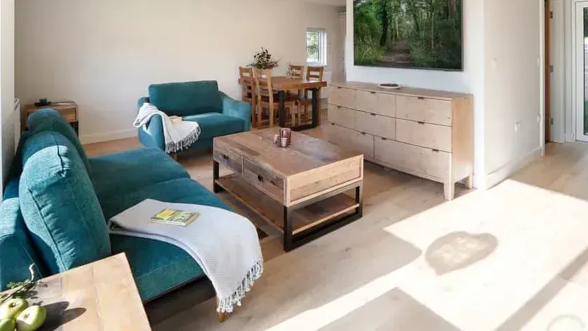 Sapphire Barn, A living room with a blue couch and a wooden coffee table.