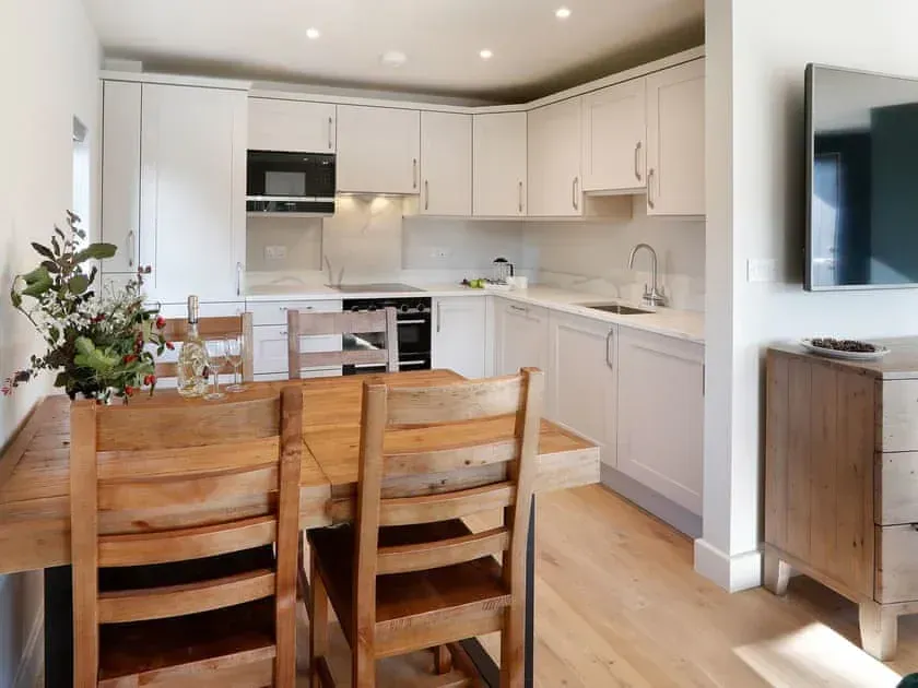 Sapphire Barn, A kitchen with a table and chairs and a flat screen tv on the wall.