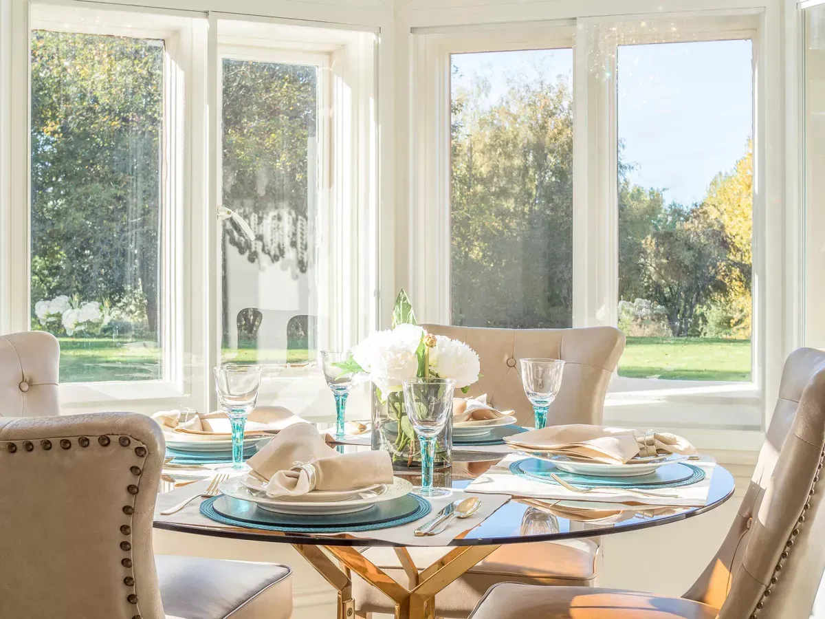 Milverton Hall, A dining room with a glass table and chairs and a lot of windows.