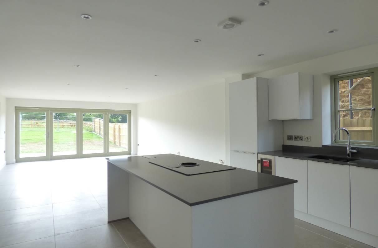 Brailes, An empty kitchen with a large island in the middle of the room.