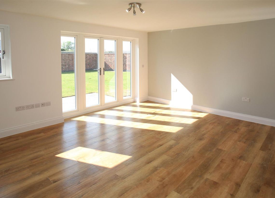 Newbold Farm,  An empty living room with hardwood floors and sliding glass doors