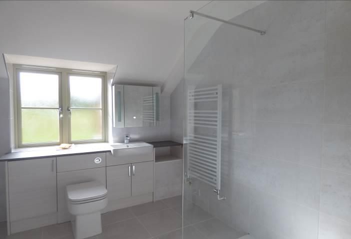 Brailes, A bathroom with a toilet , sink , and walk in shower.