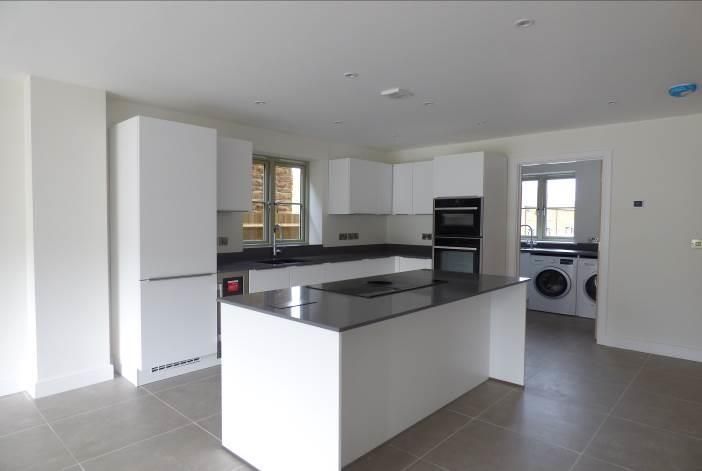 Brailes, A kitchen with white cabinets and a large island in the middle