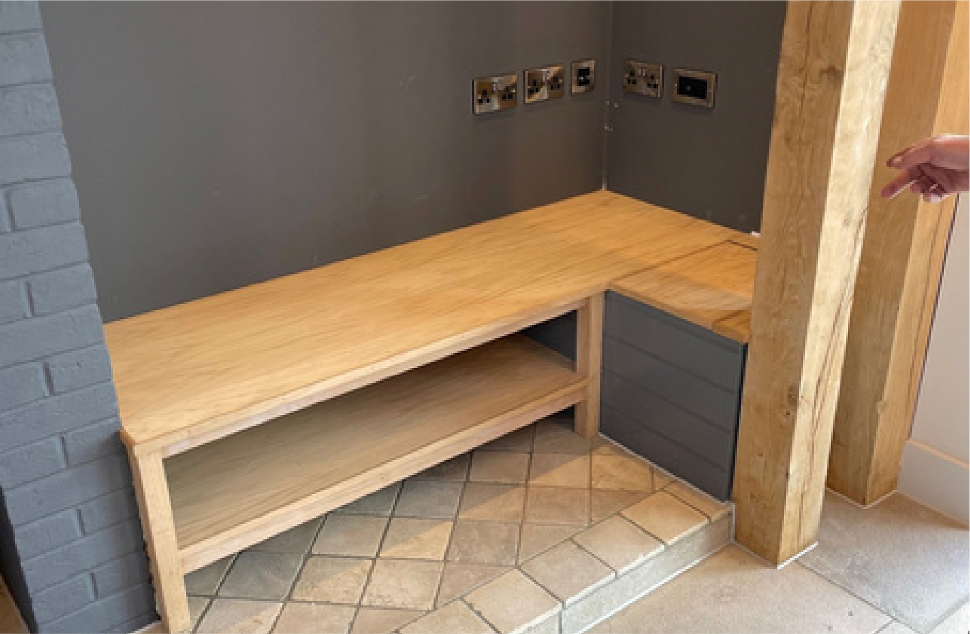 Kingfisher Barn, A person is pointing at a wooden bench in a room.