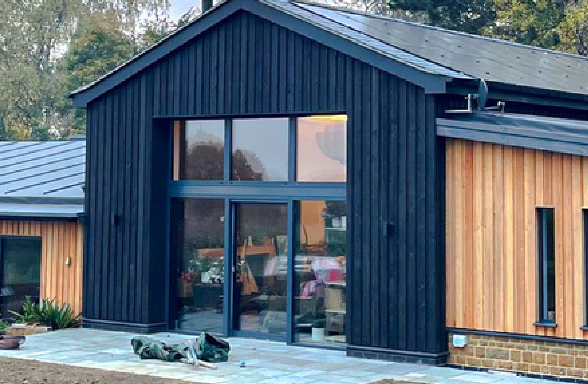 Kingfisher Barn, A large house with a lot of windows and a black roof.