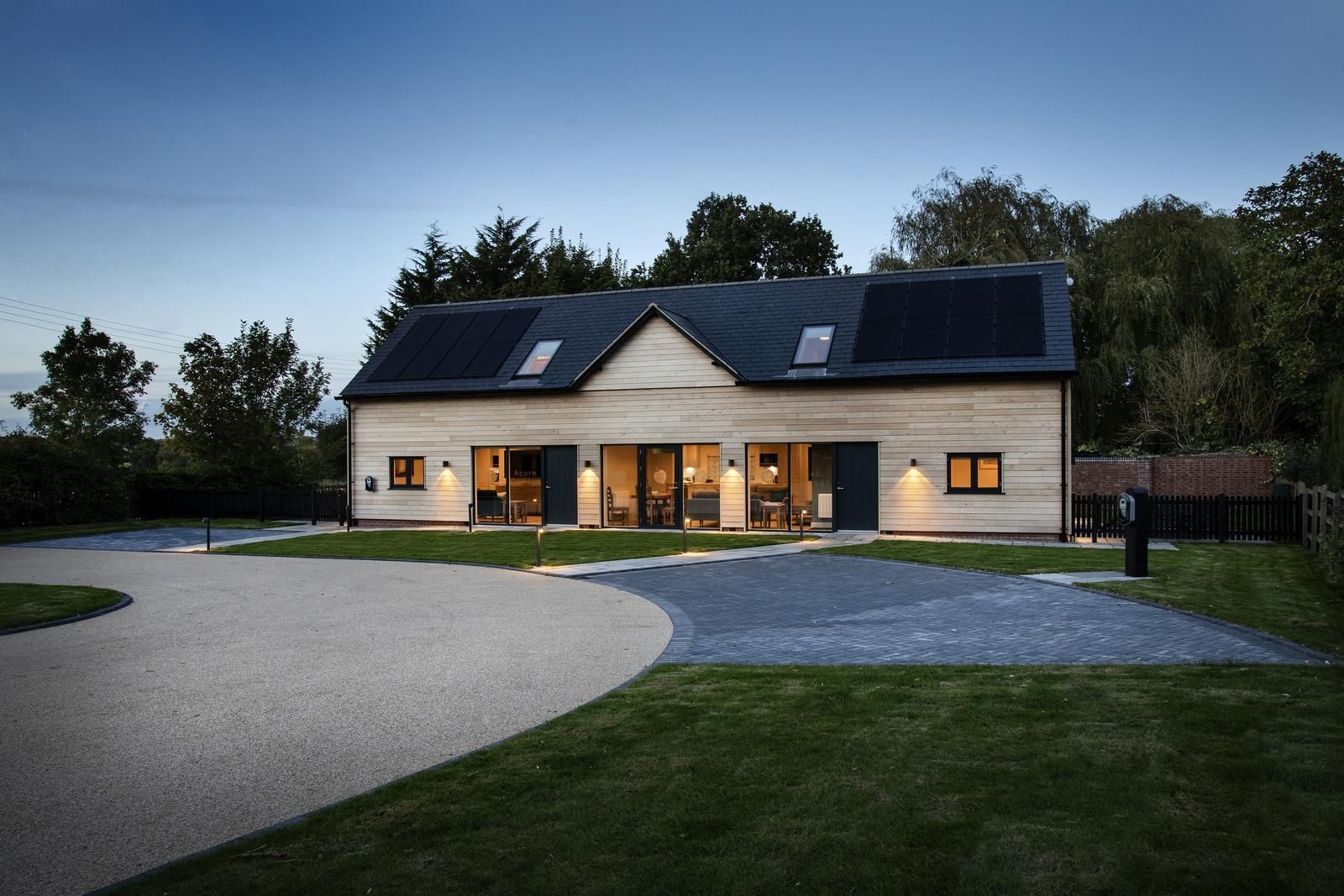 Sapphire Barn, A large house with a lot of windows and solar panels on the roof.