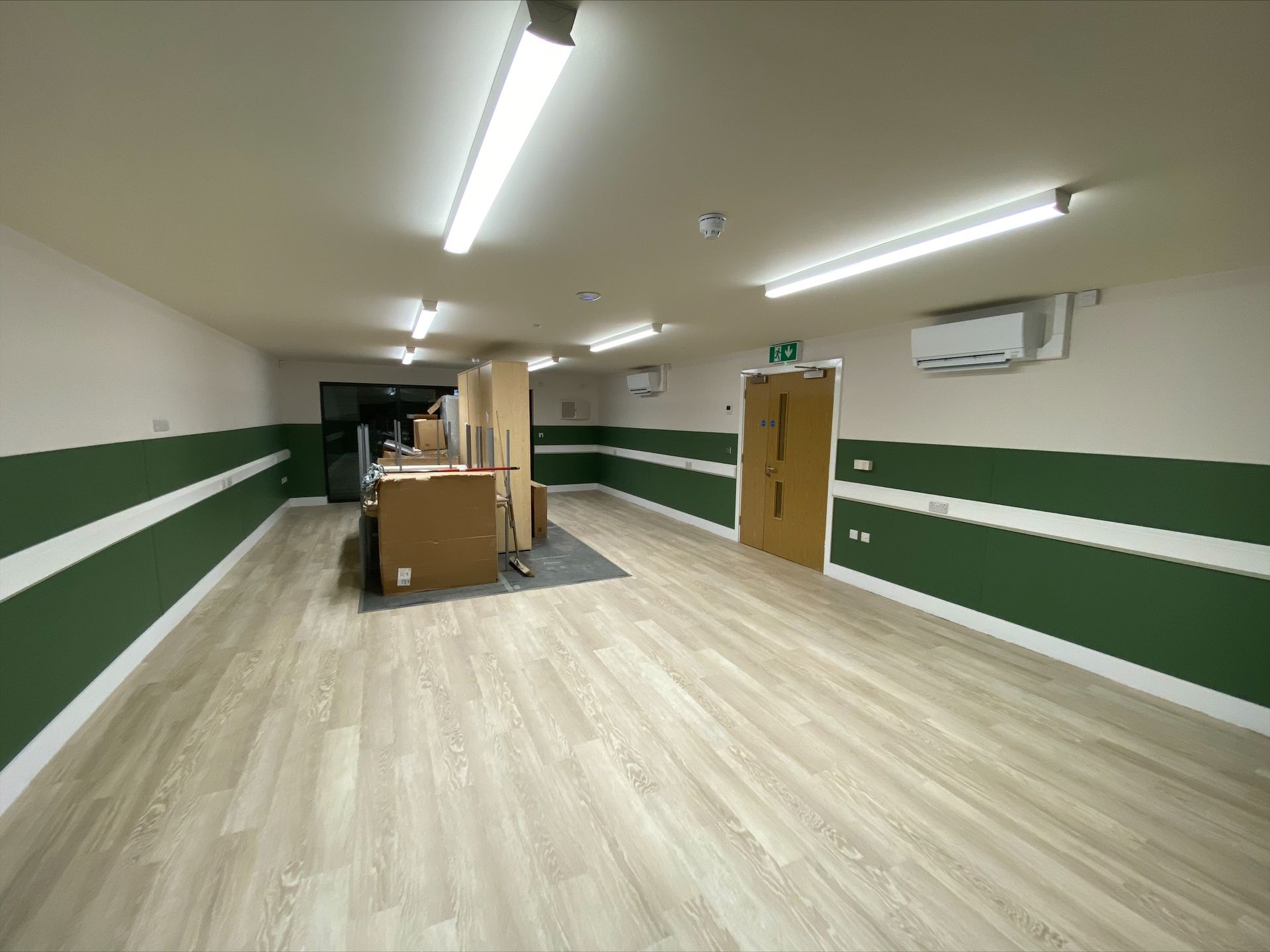 Gorcott Hill Park, A large empty room with wooden floors and green and white walls.