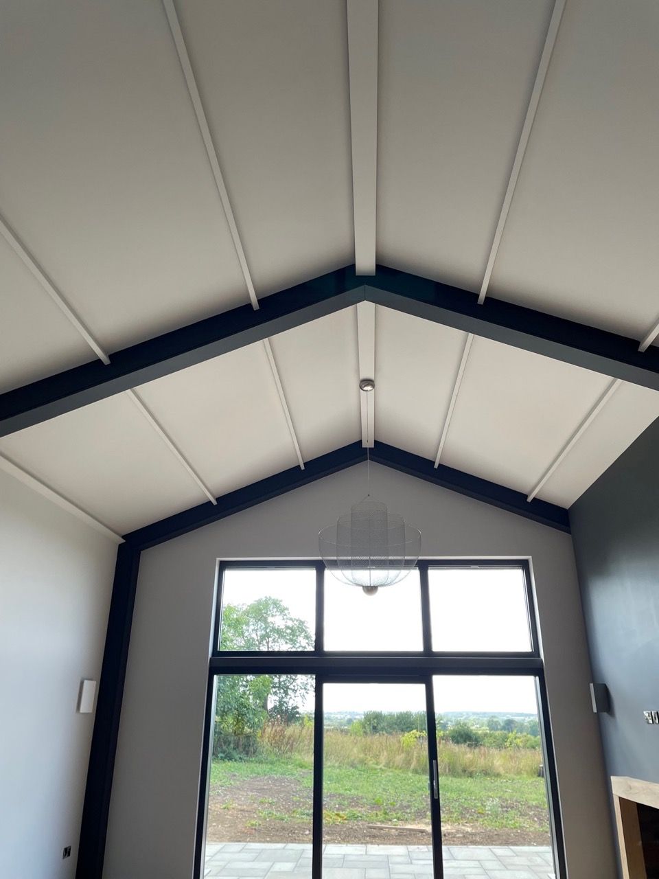 Kingfisher Barn, A room with a large window and a vaulted ceiling.