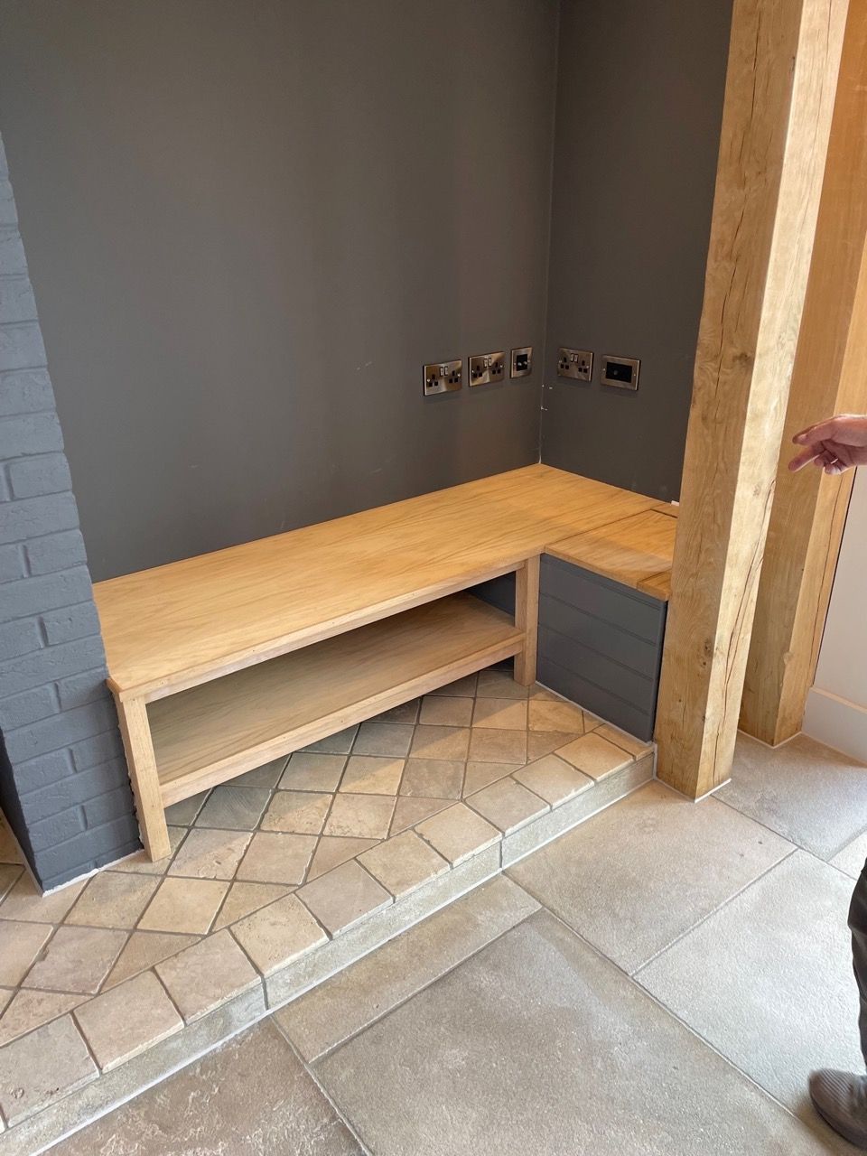 Kingfisher Barn, A person is standing in a room with a wooden bench and a shelf.