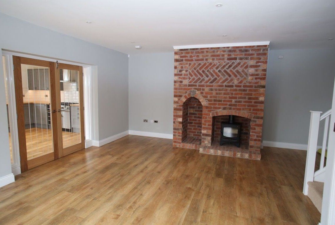 Newbold Farm,  A living room with hardwood floors and a brick fireplace