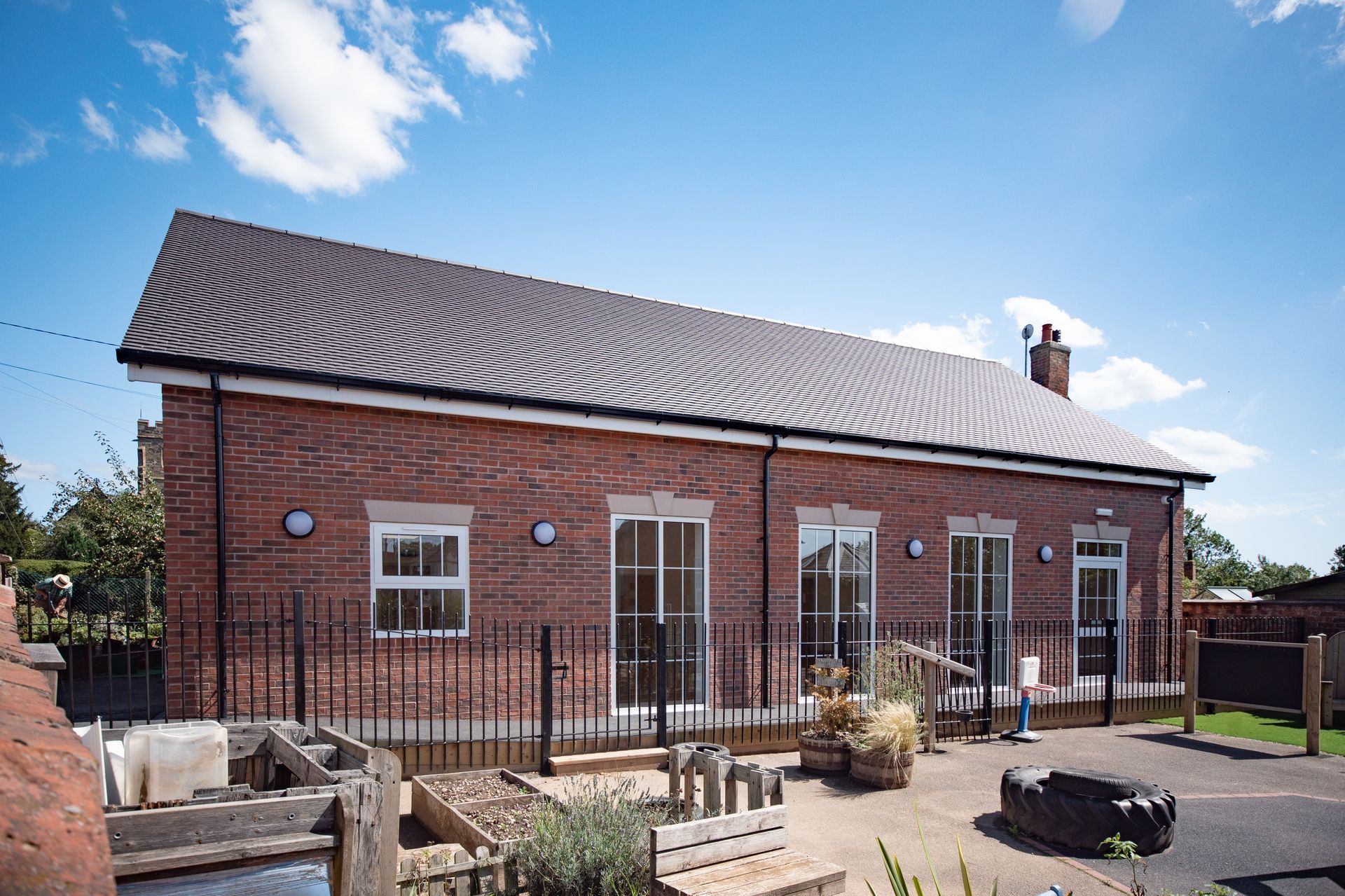 Old School Community Room, A large brick building with a lot of windows and a fence around it
