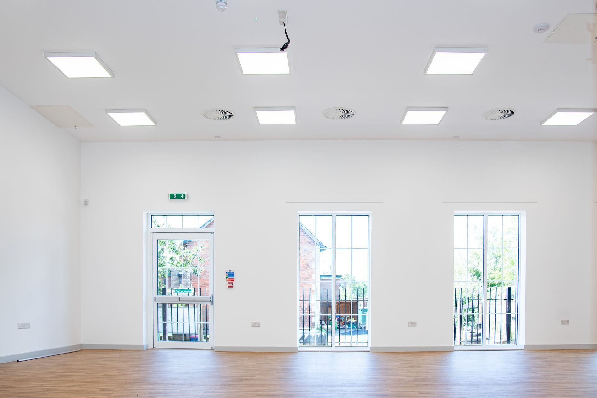 Old School Community Room, A large empty room with hardwood floors and white walls.