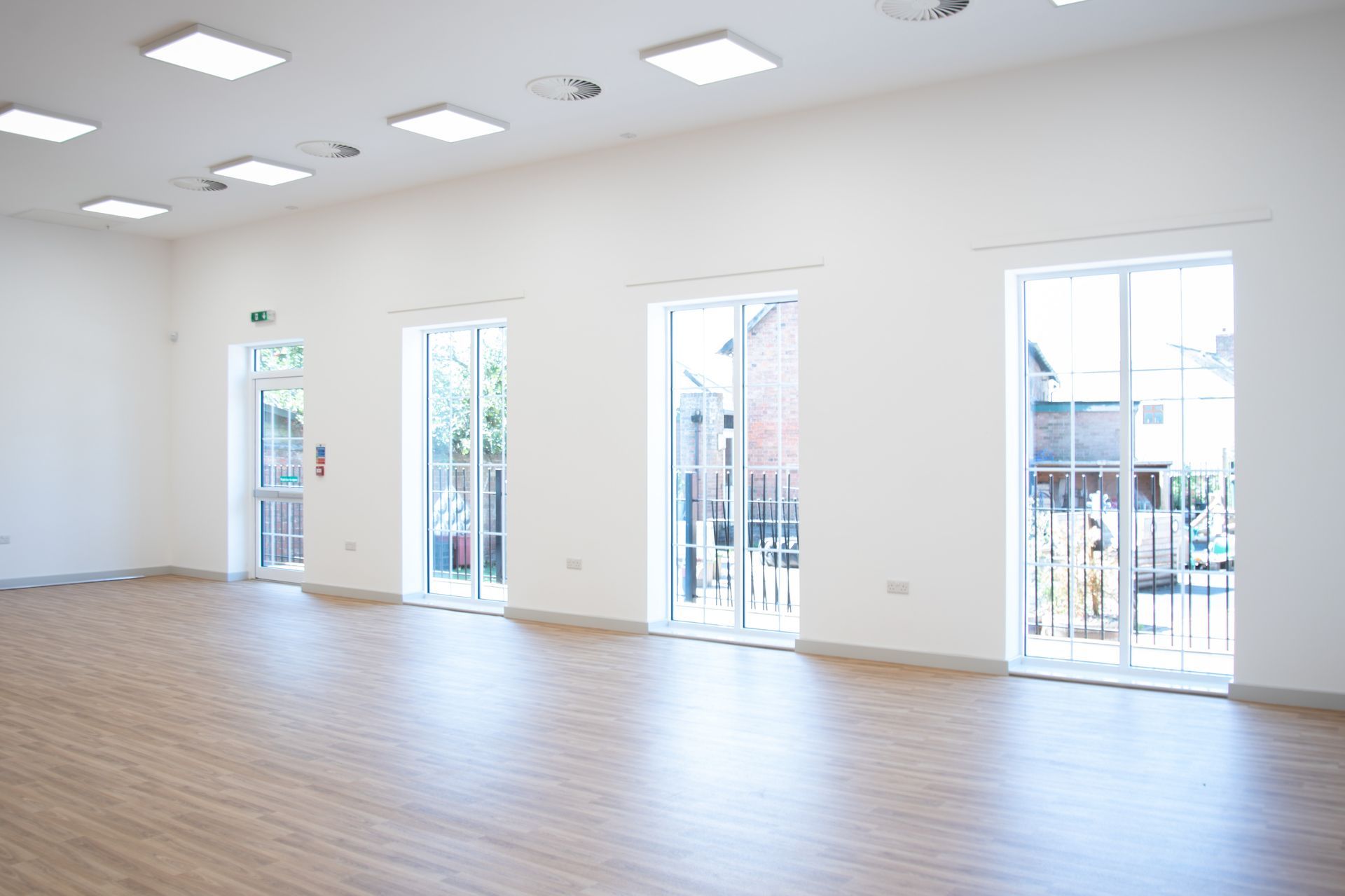 Old School Community Room, A large empty room with lots of windows and wooden floors.
