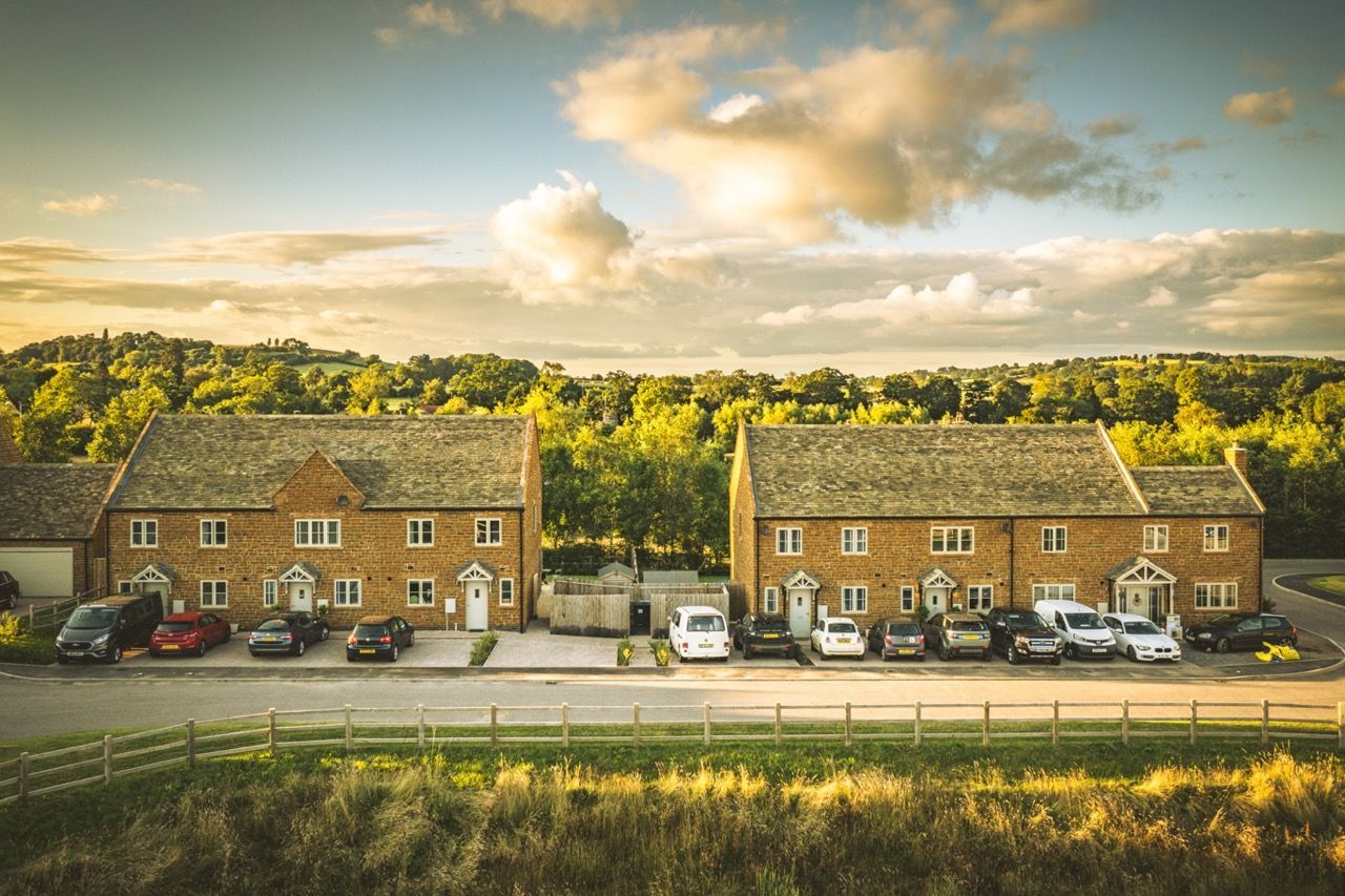 Brailes, An aerial view of a row of houses with cars parked in front of them.