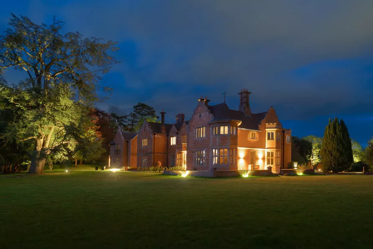 Milverton Hall, A large brick house is lit up at night.
