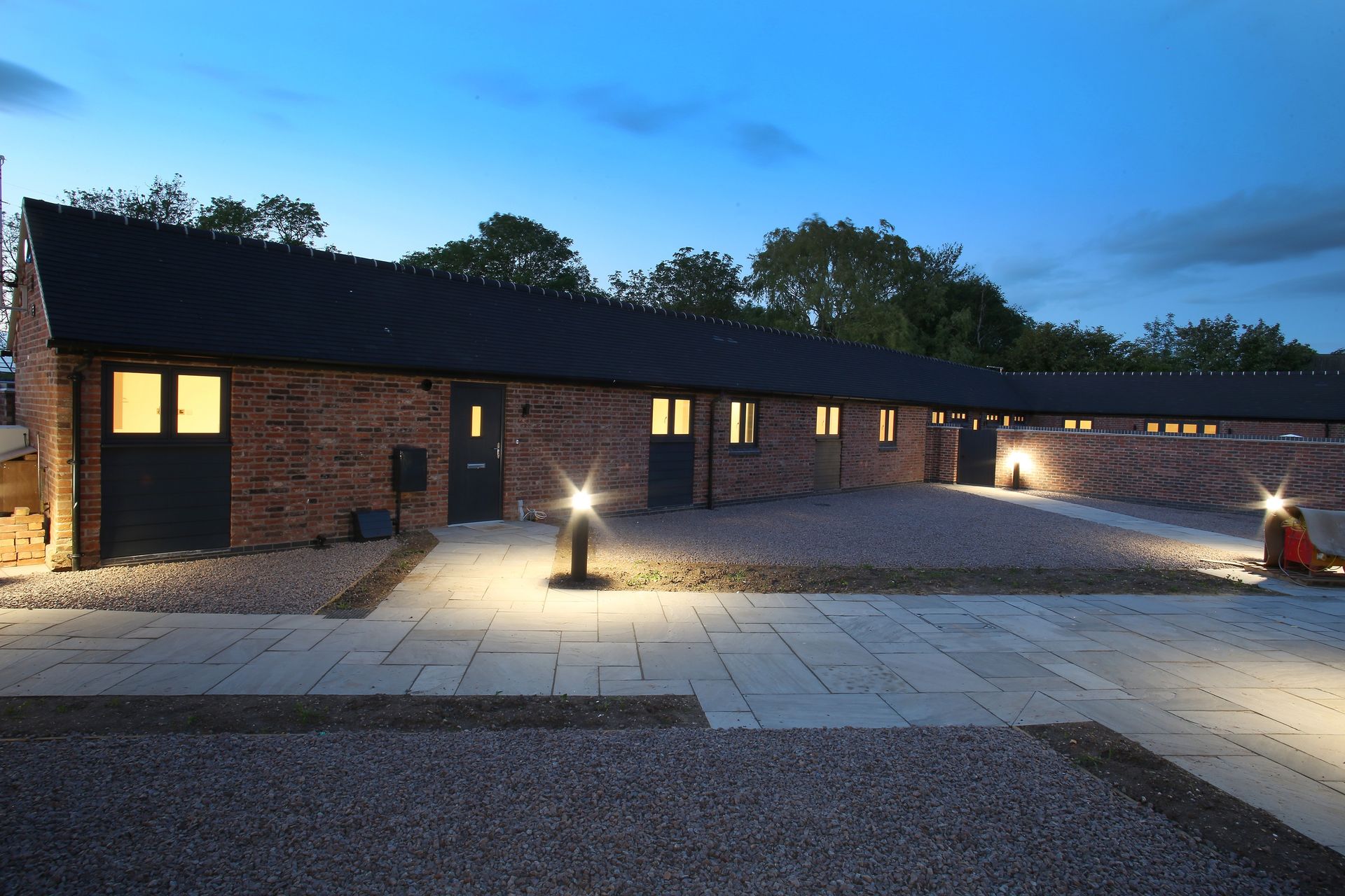 Newbold Farm, a row of brick buildings are lit up at night