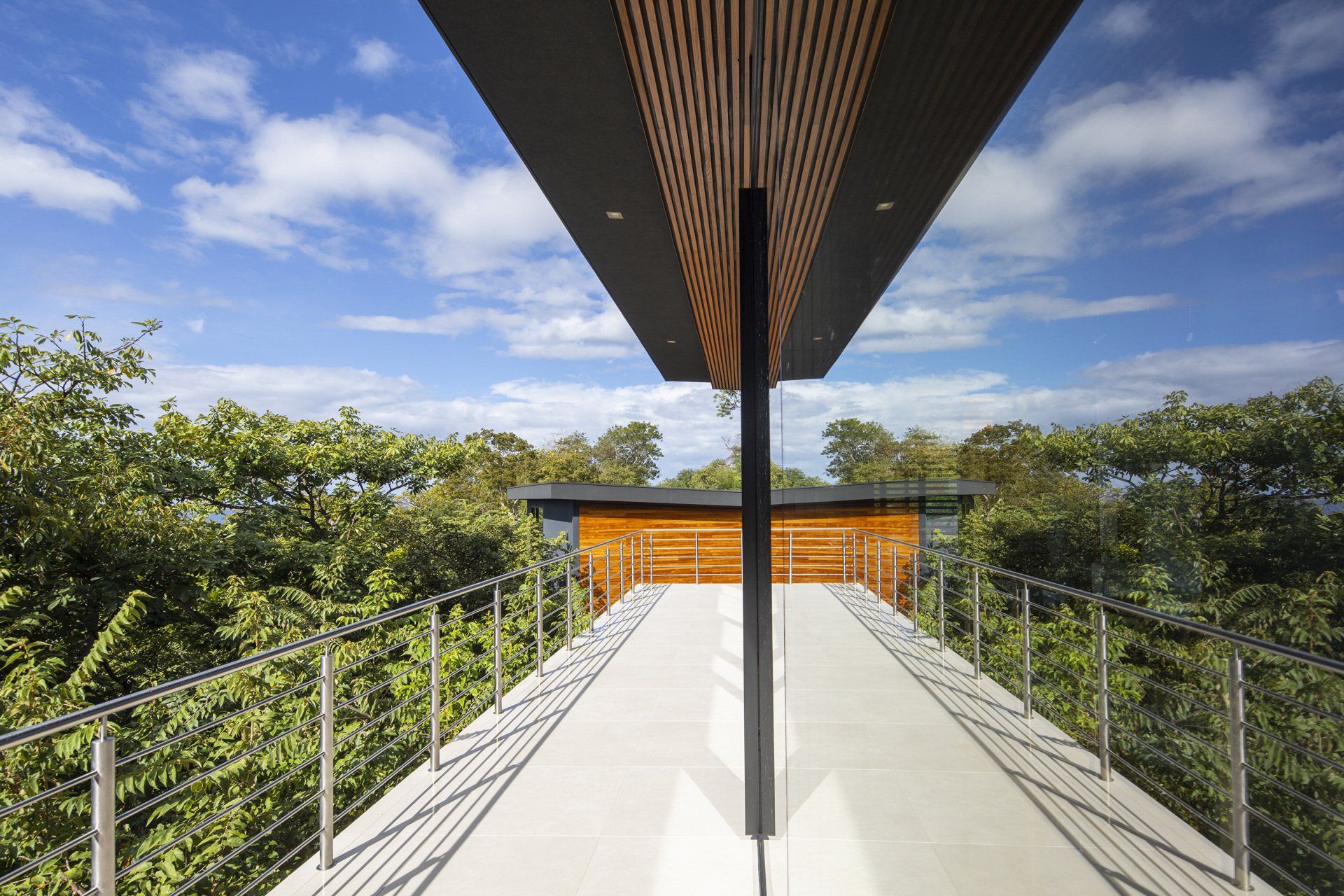 a bridge leading to a house with trees in the background - casa aramara by sarco