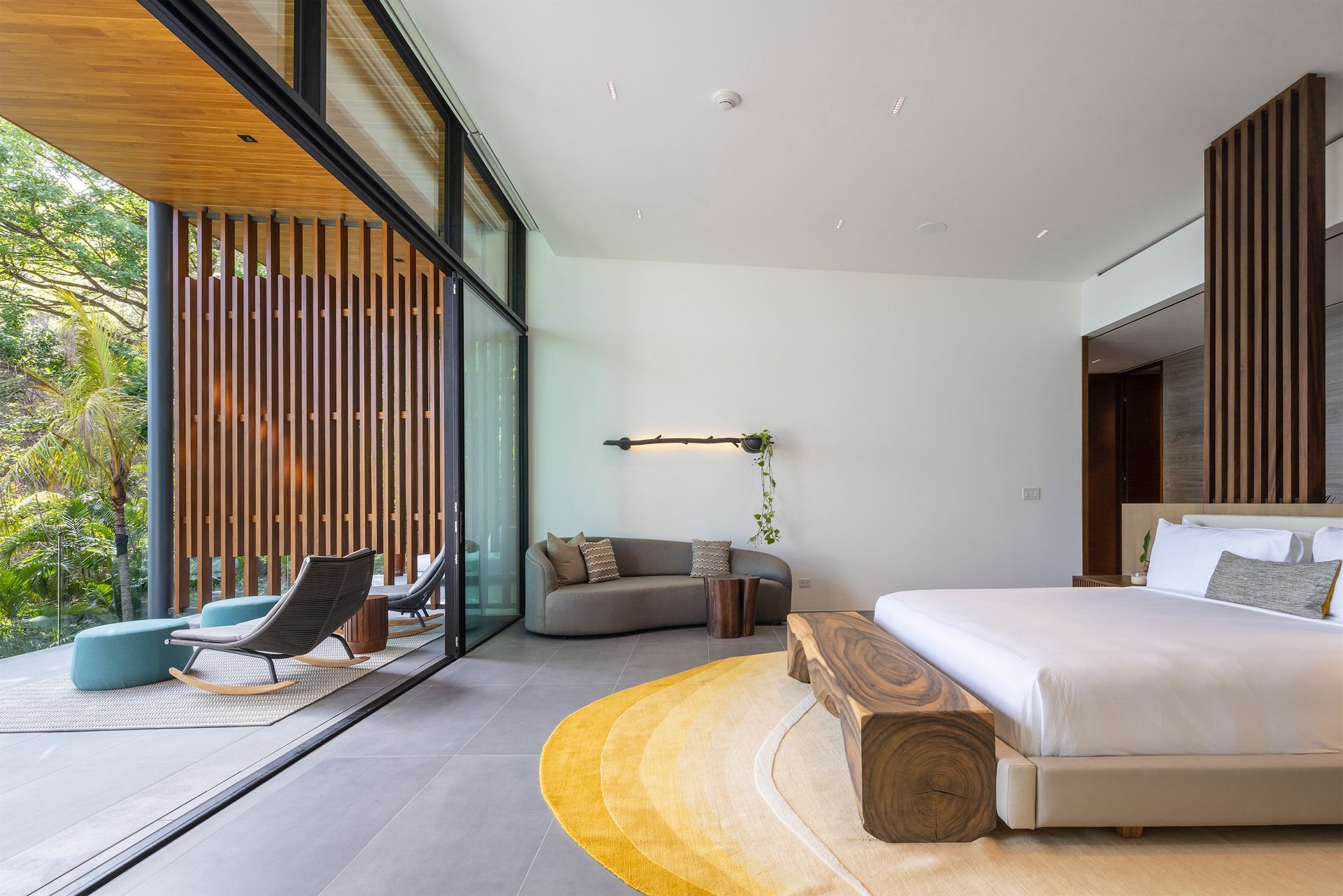 a bedroom with a large bed , couch , chairs and a large window .
