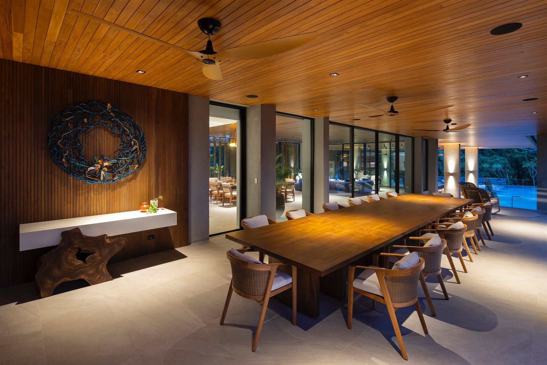 Covered patio with large wooden dining table, chairs, and wood ceiling.