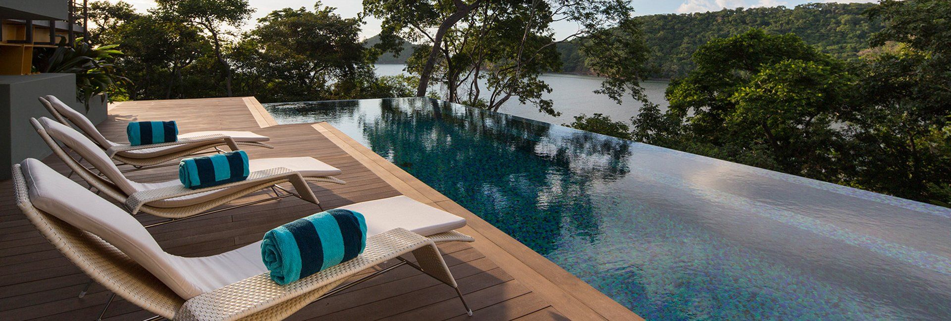 a row of lounge chairs sitting next to an infinity pool .