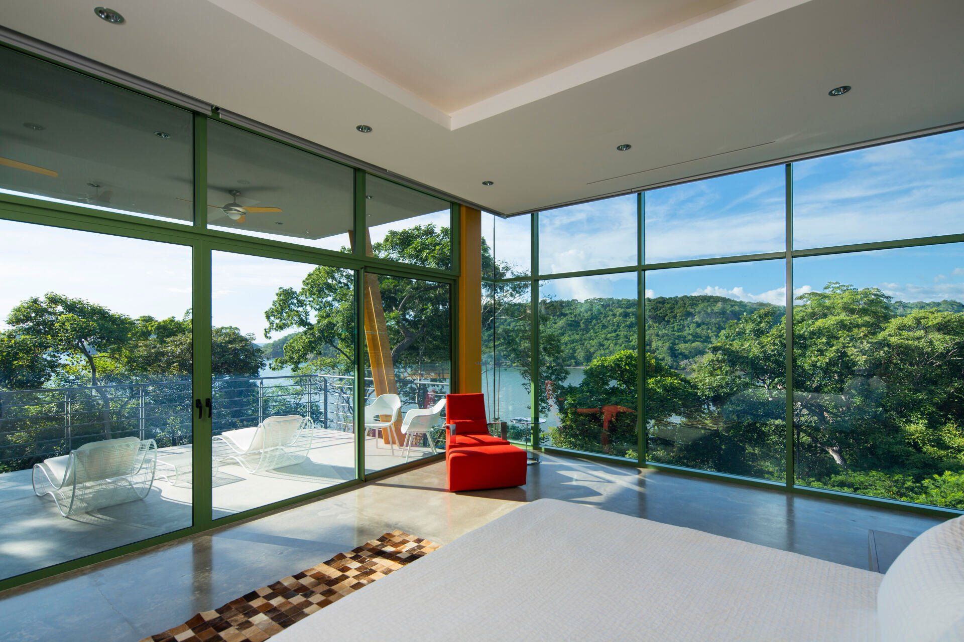 a bedroom with a large bed and lots of windows