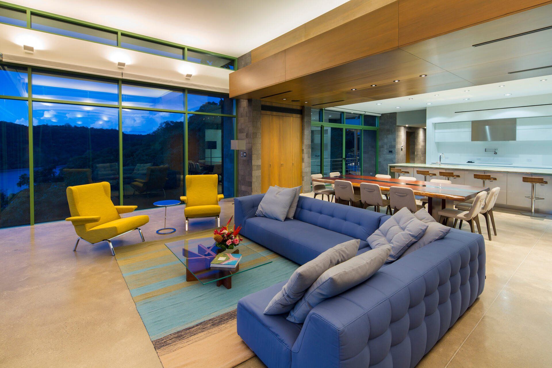 a living room with a blue couch and yellow chairs
