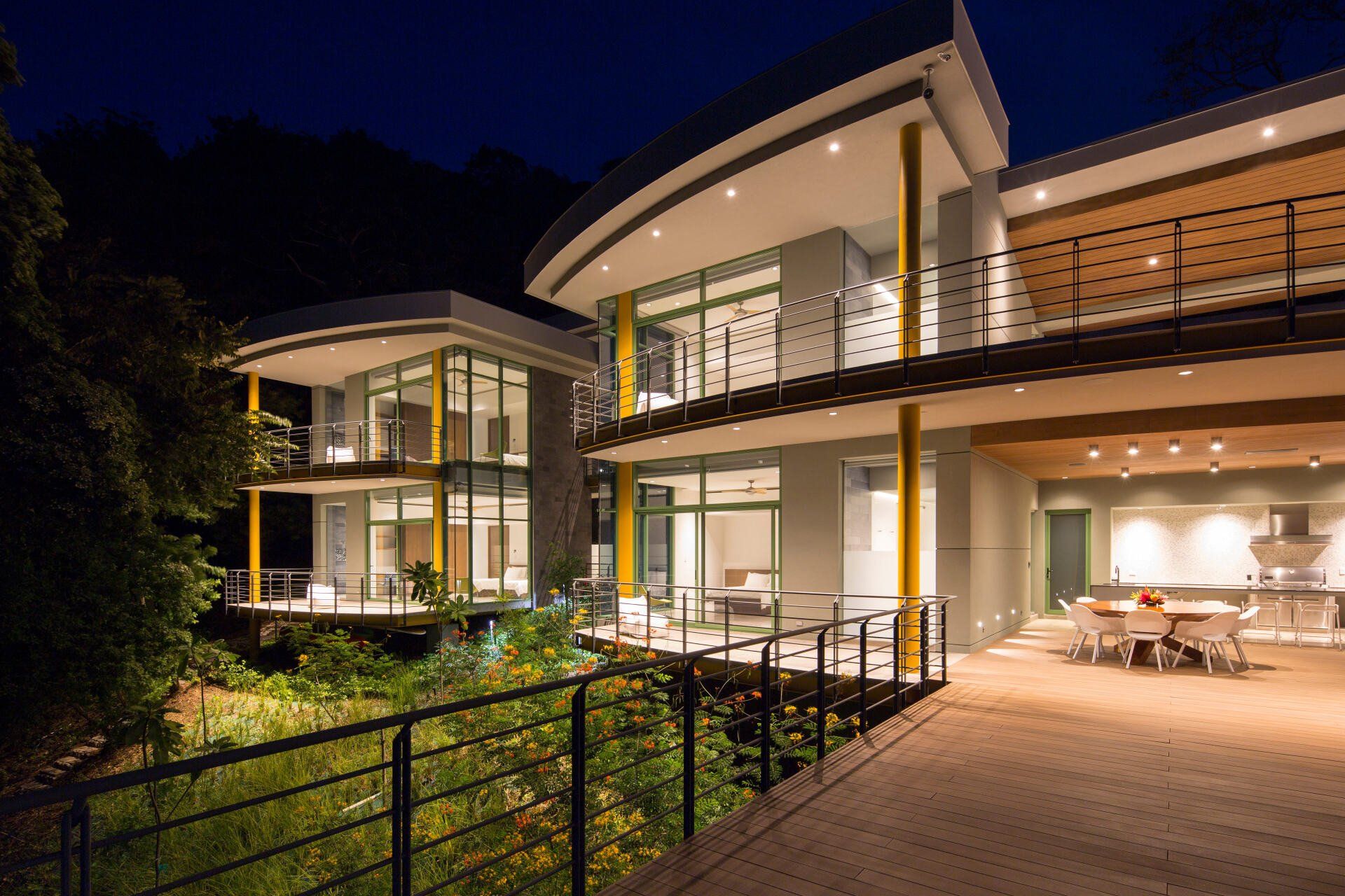 a large house with a lot of windows is lit up at night . casa magayon by sarco
