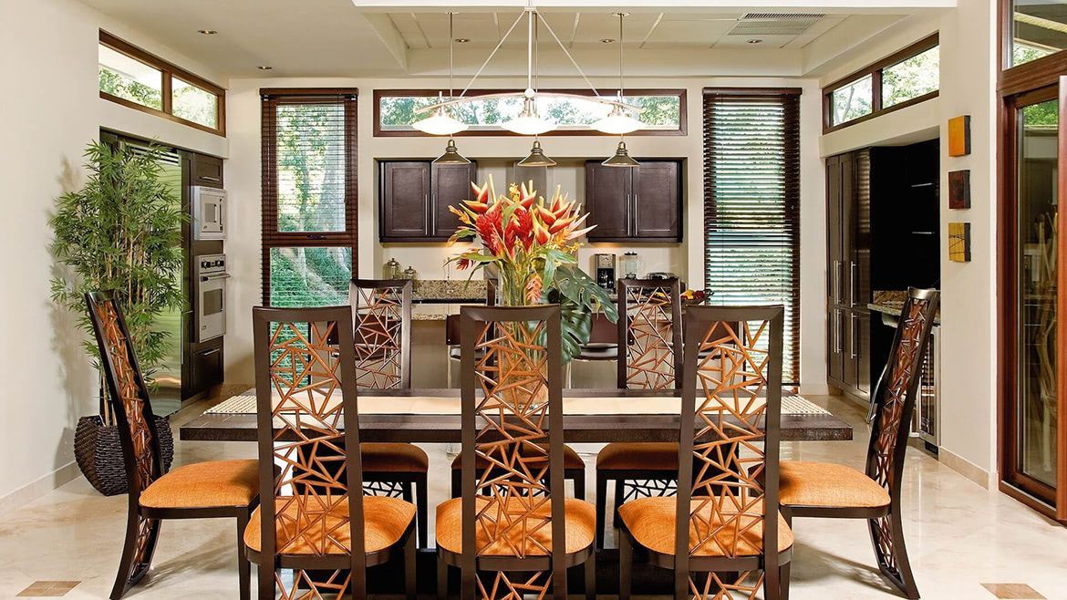 a dining room with a table and chairs and a vase of flowers