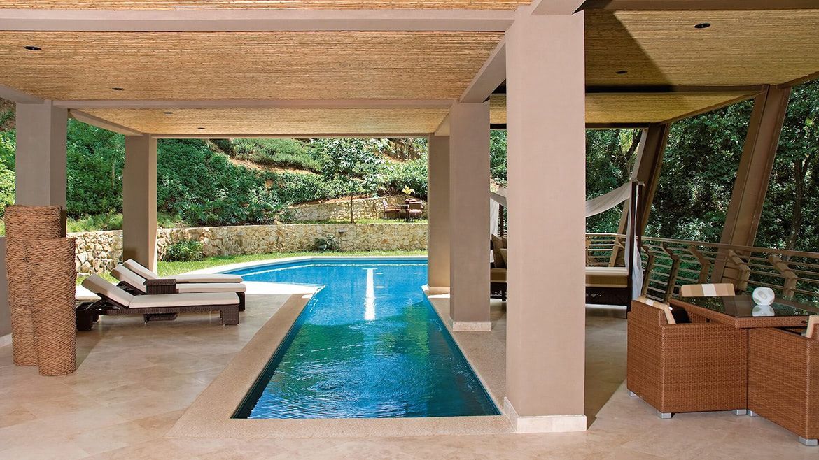 a large swimming pool is surrounded by chairs and a table