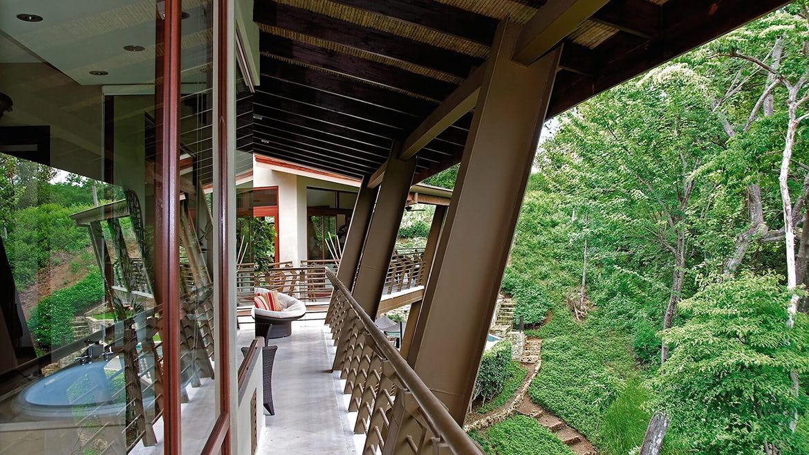 a balcony with a view of a lush green forest
