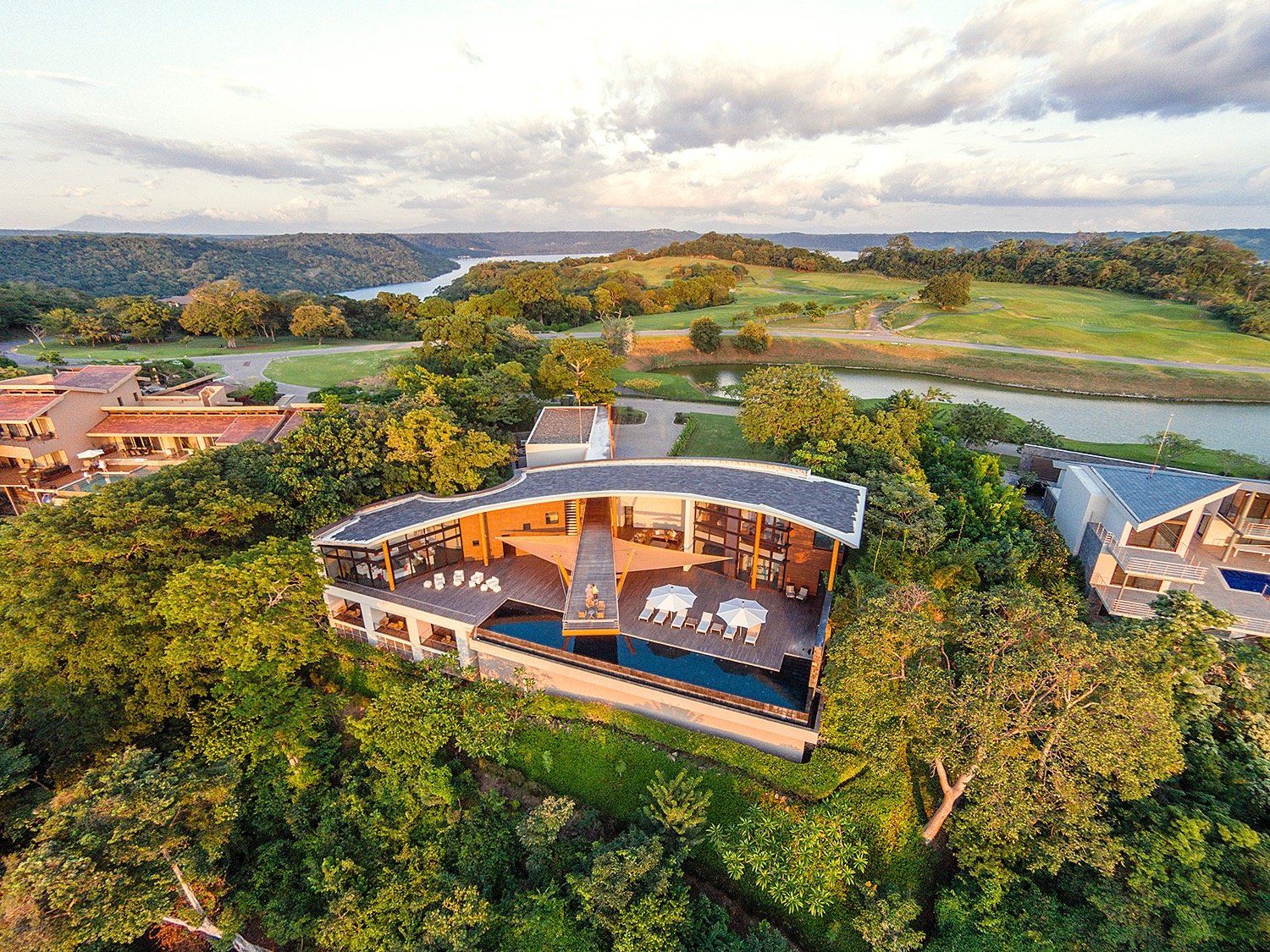 an aerial view of a house surrounded by trees and a river .