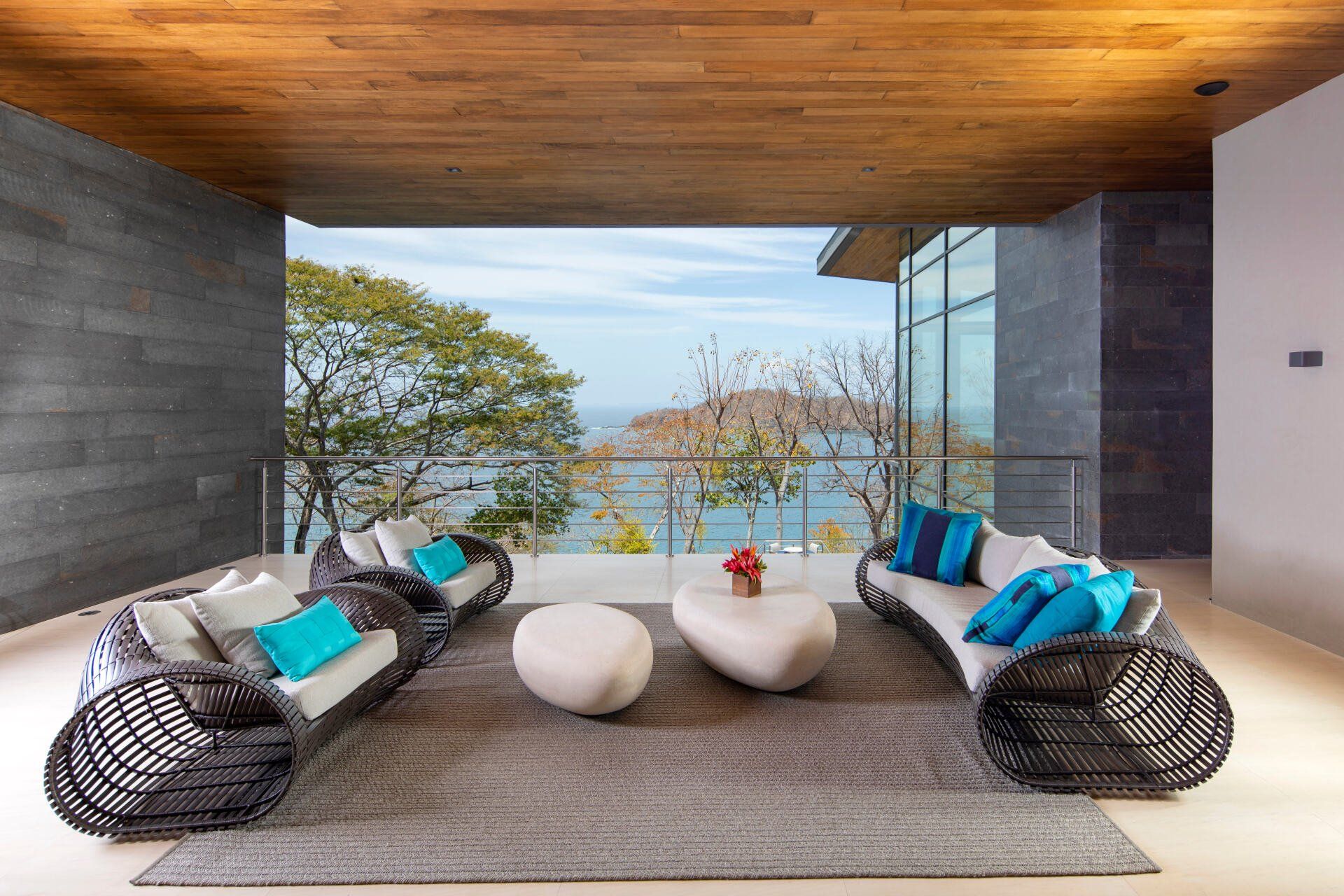 a living room with wicker furniture and a view of the ocean
