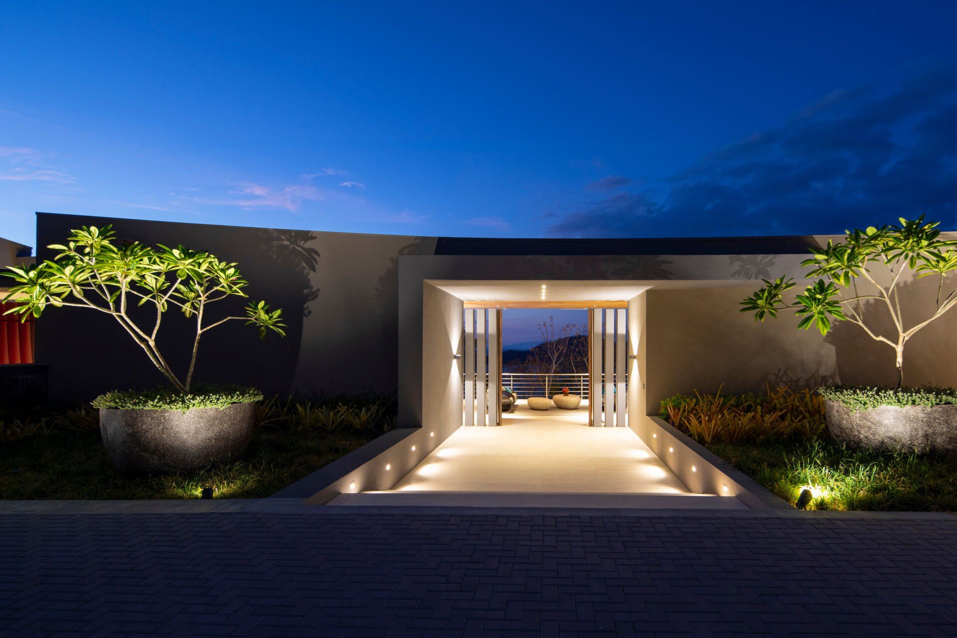 the entrance to a modern house is lit up at night