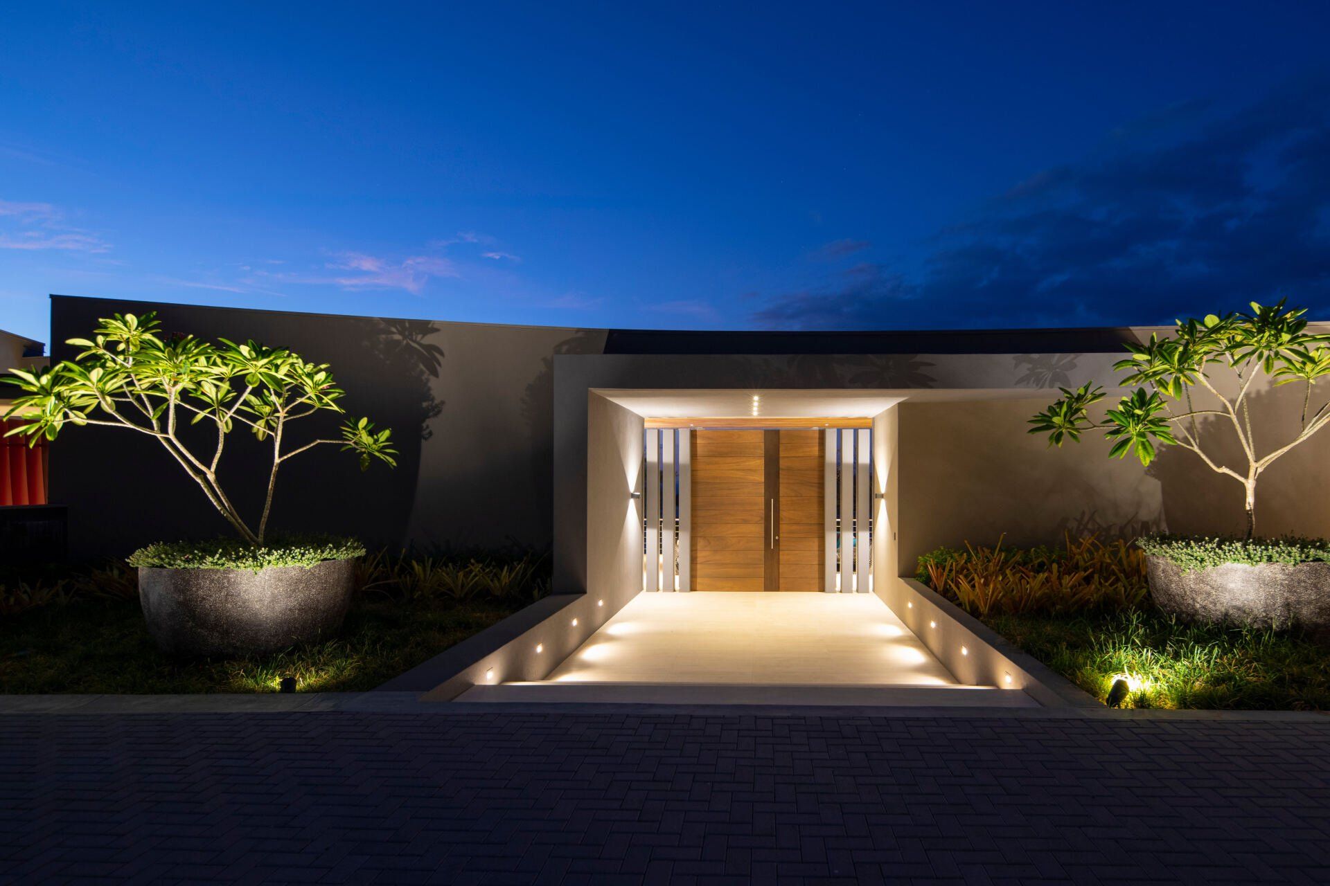 the entrance to a modern house is lit up at night