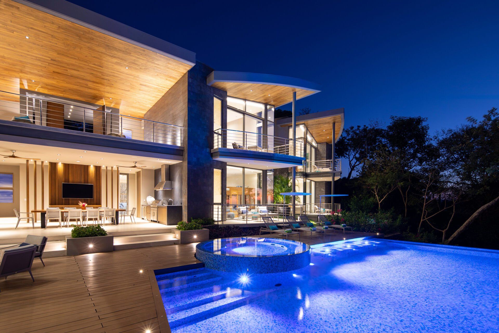 a large house with a swimming pool in front of it at night .