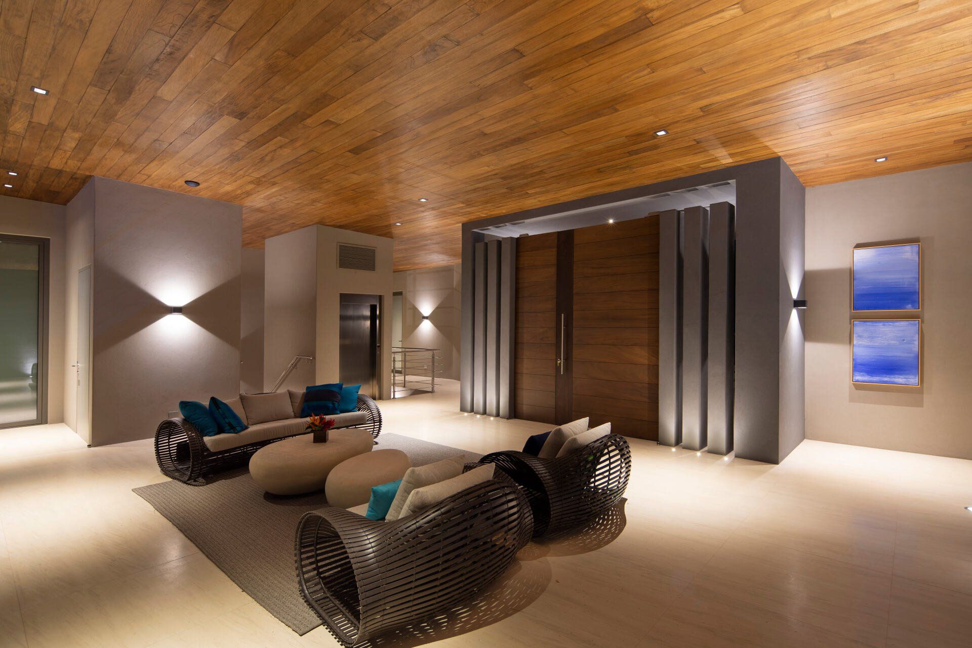 a living room with a wooden ceiling and a couch and chairs