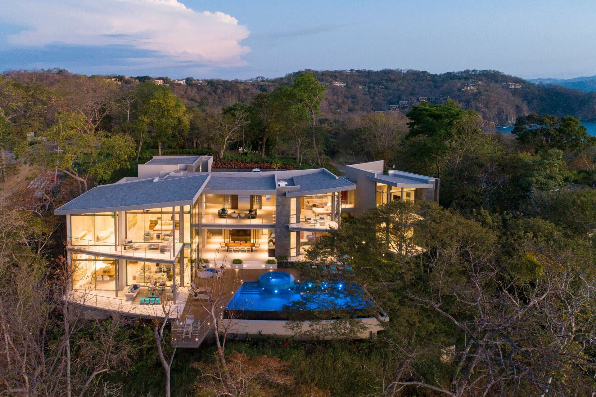 an aerial view of a large house with a swimming pool surrounded by trees .