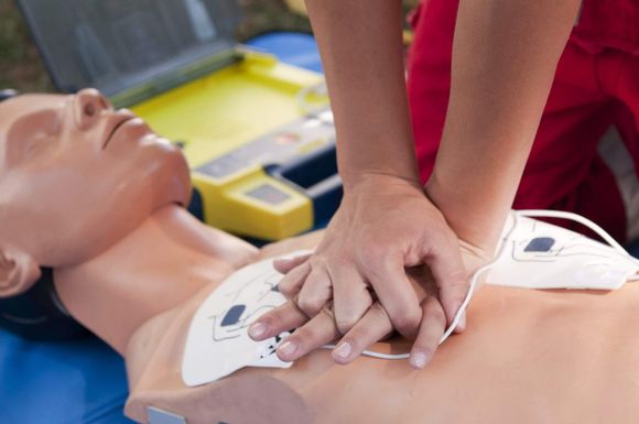 A person is performing a heart massage on a mannequin.