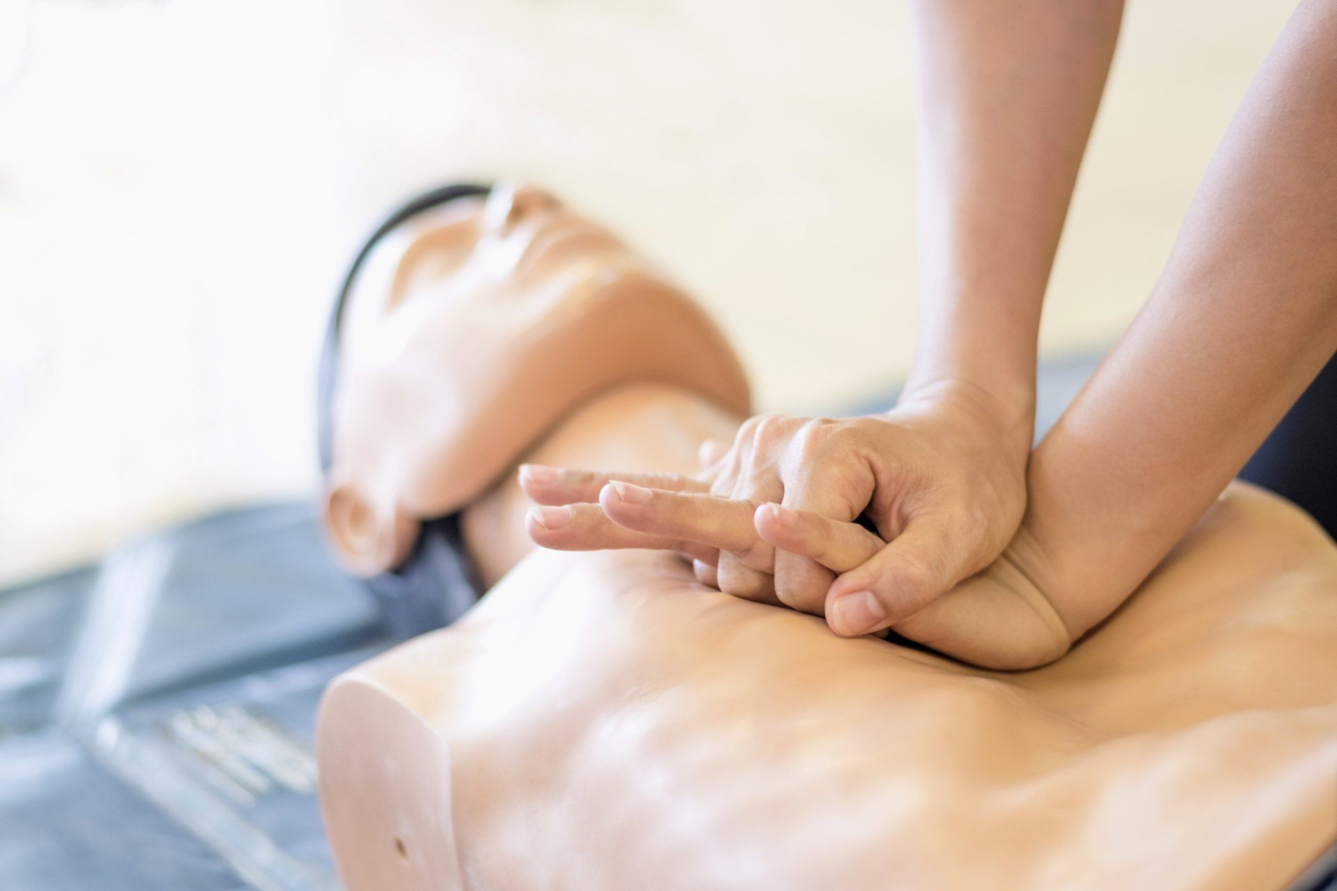 A person is doing a resuscitation on a mannequin.