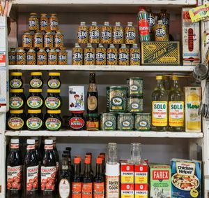 Shelf stocked with assorted condiments, sauces, and packaged foods in colorful jars and bottles