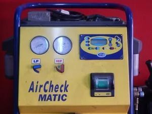 Yellow AirCheck MATIC machine with gauges and control panel on a red background