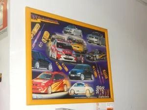 Framed poster of colorful racing cars on a wall