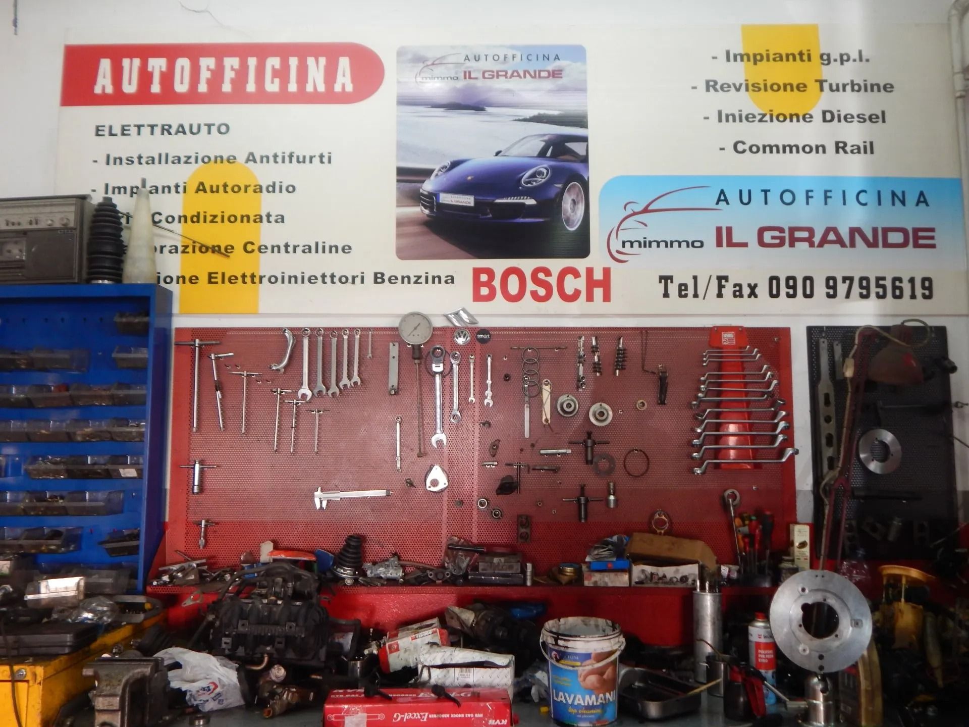 Auto repair shop wall with tools, Bosch branding, and car service signs in Italian