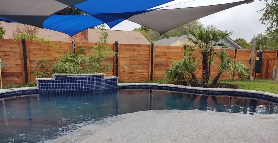 A swimming pool with a blue and white umbrella over it.
