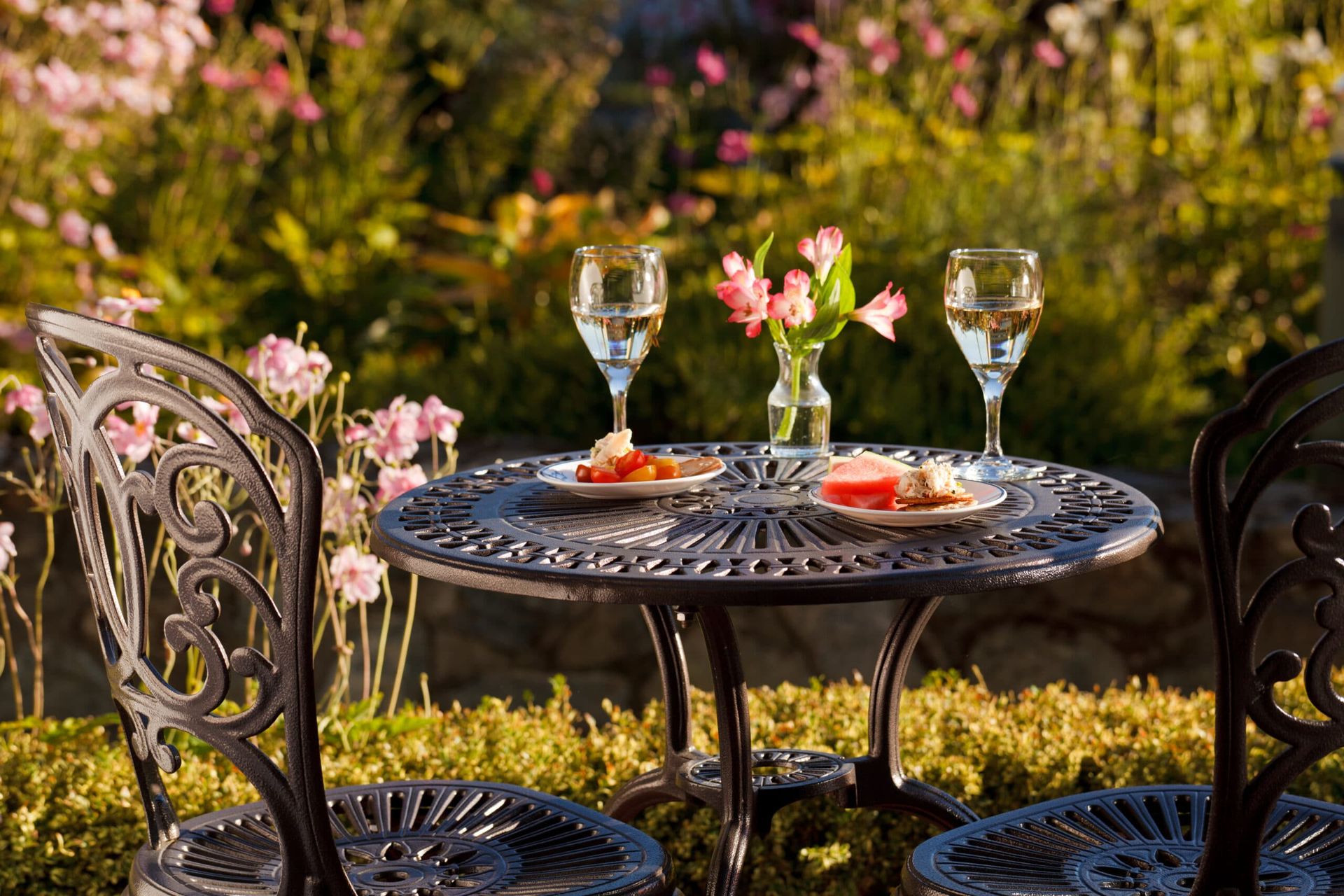 Evening appetizers with wine glasses on it in a garden.
