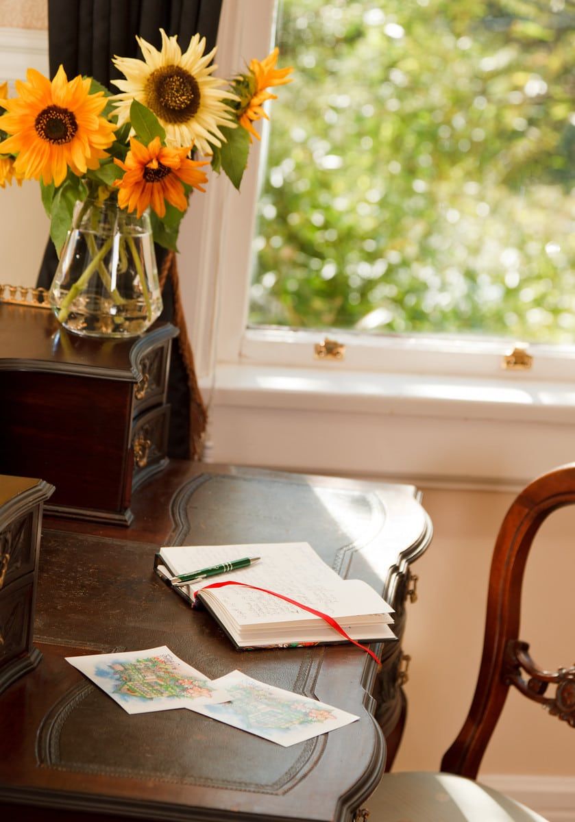 A desk with a vase of sunflowers on it