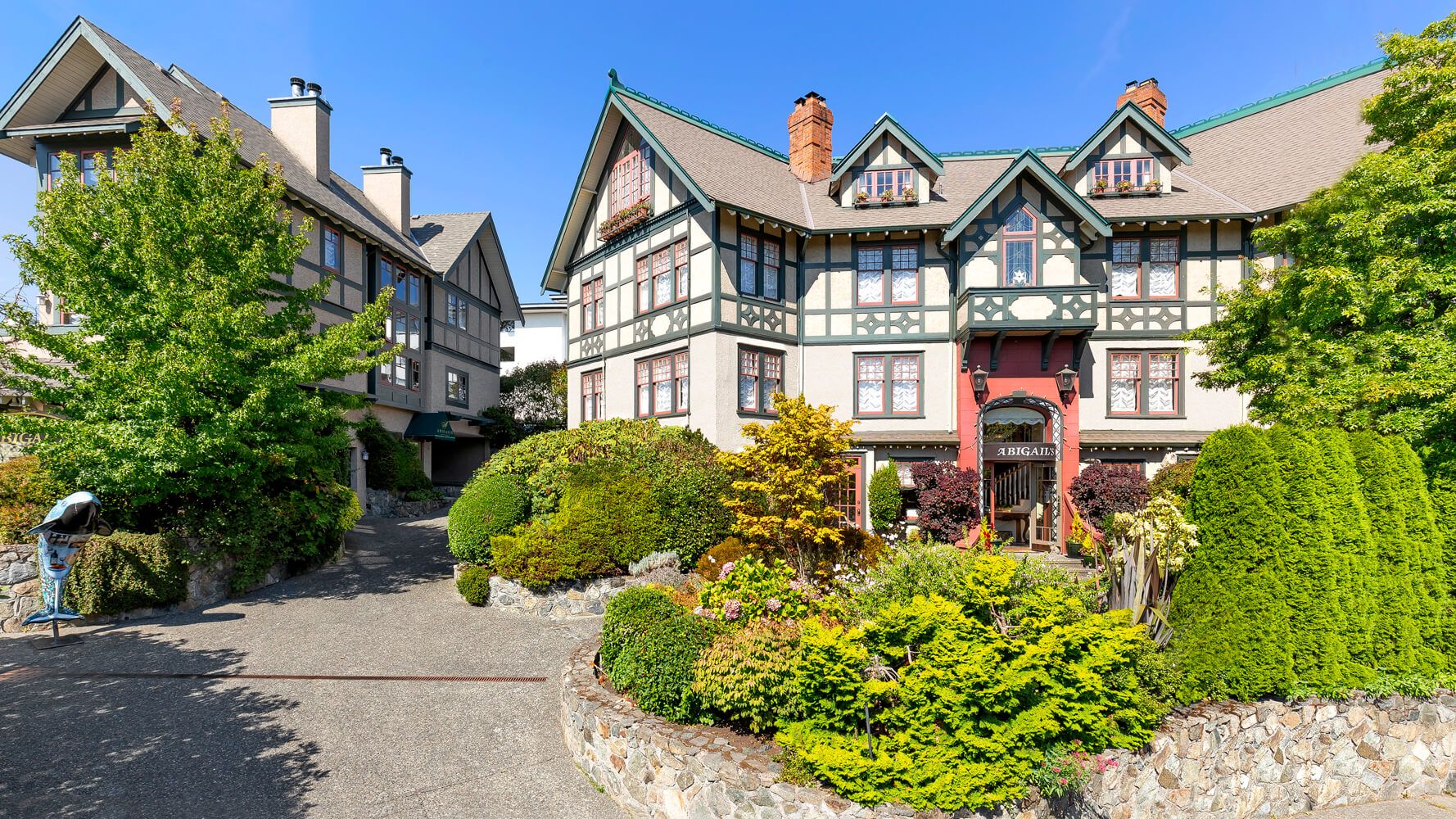 A large house with a lot of windows is surrounded by trees and bushes.