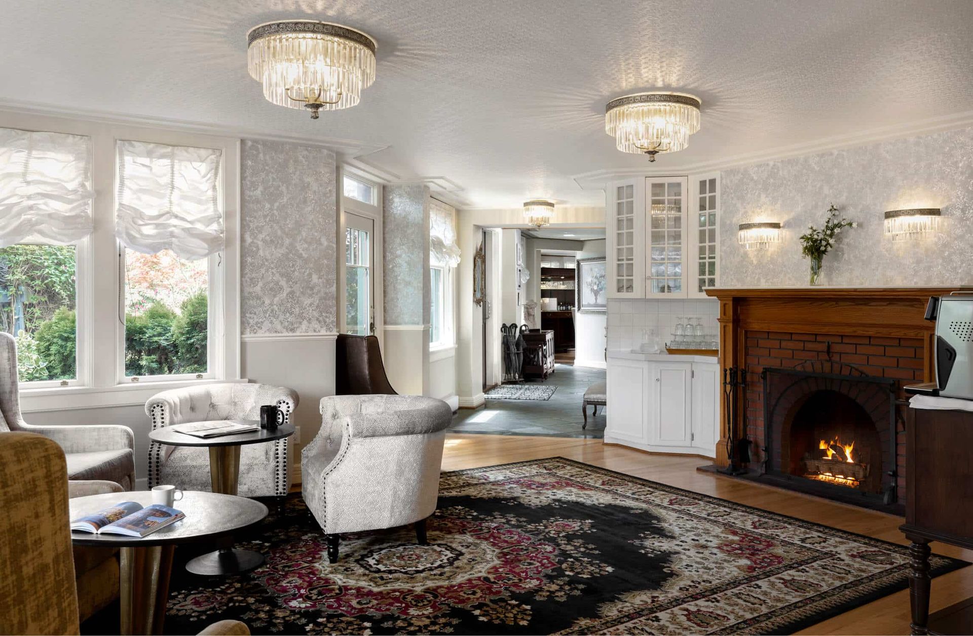 Coffee lounge with fireplace , chairs , tables and a rug.